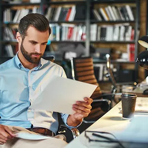Student reading book in library wearing mask